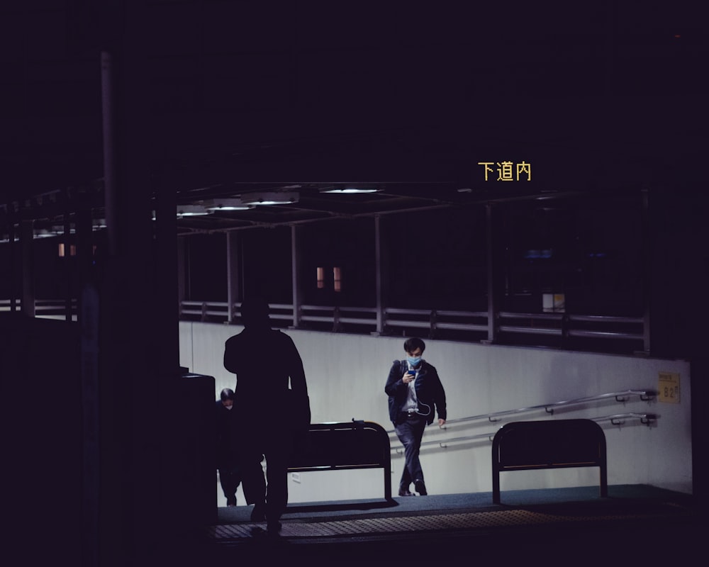 man in black coat walking on train station