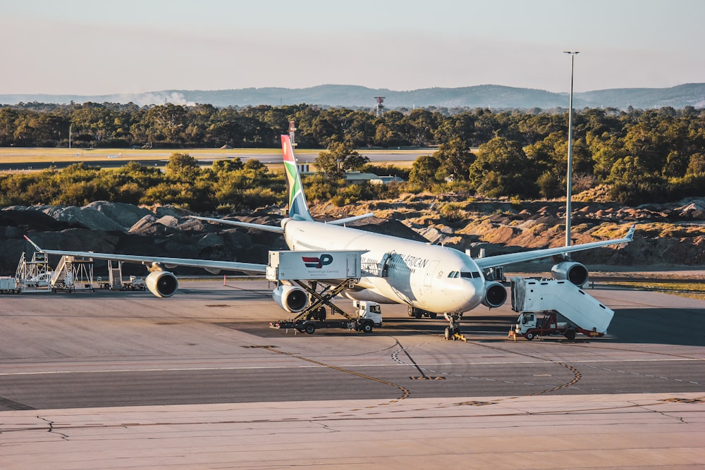 white and blue airplane on airport during daytime