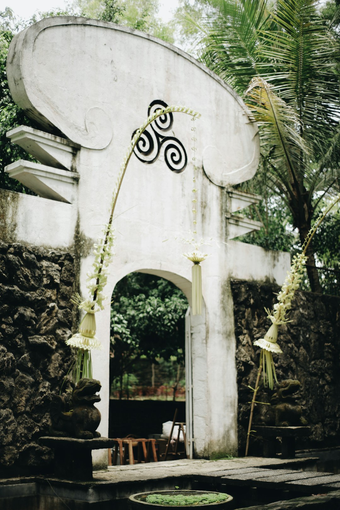 white concrete arch with green plants