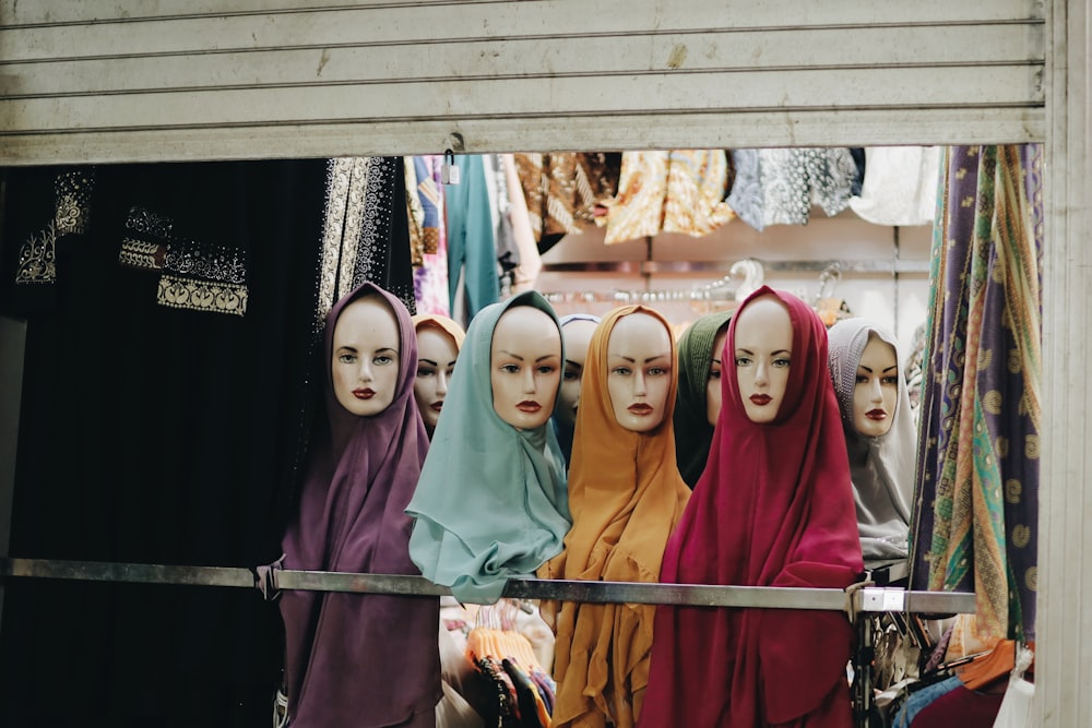 women in hijab standing near brown wooden wall