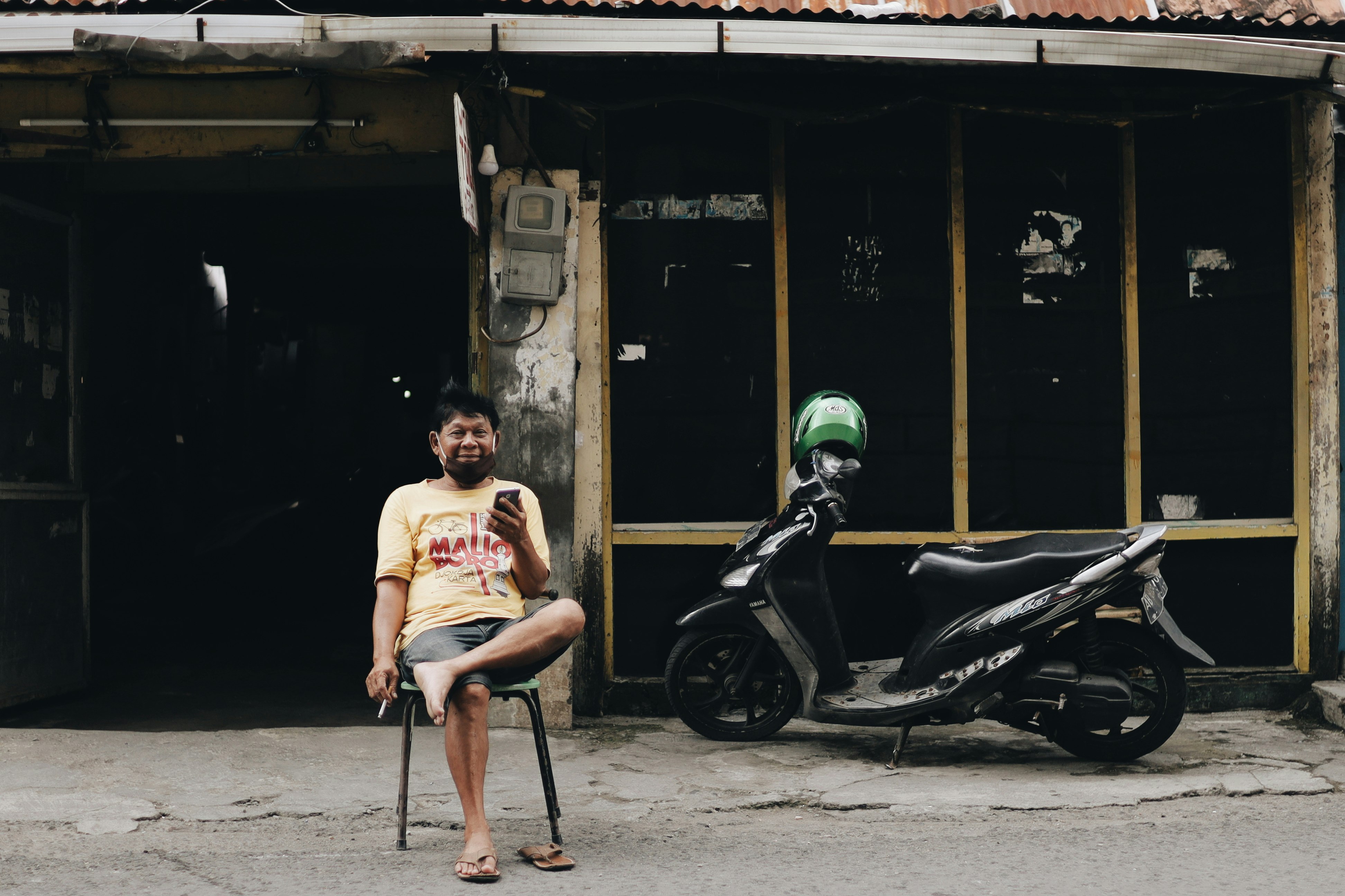 man in white tank top sitting on black motorcycle