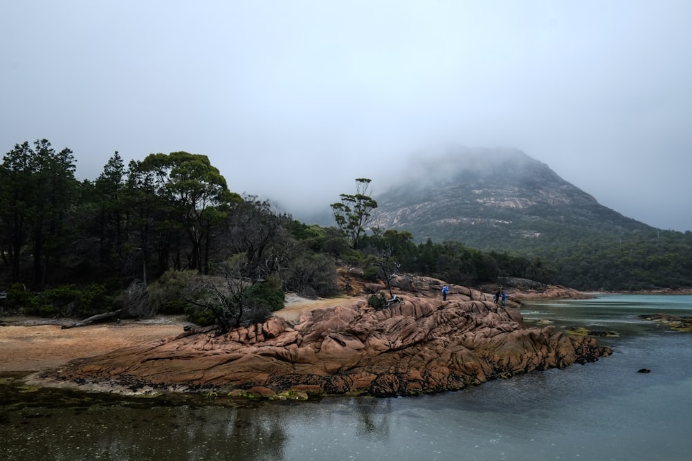 brown rock formation beside body of water during daytime