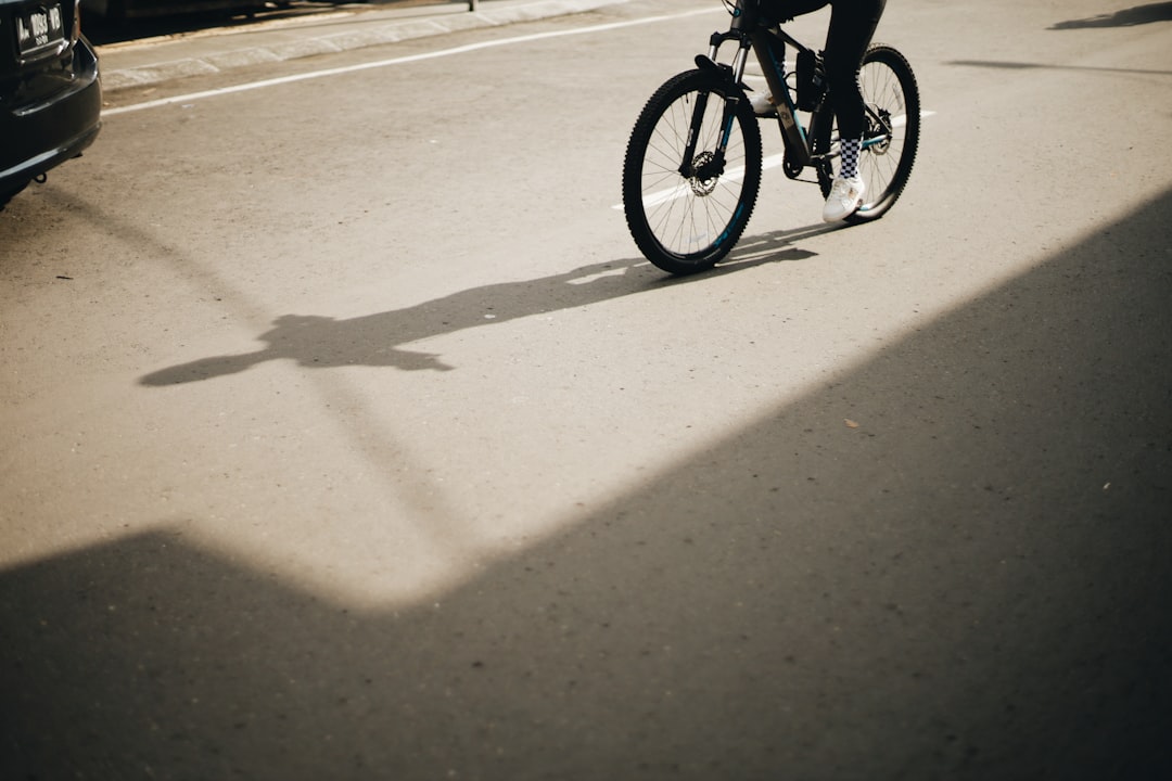 person riding on bicycle on road during daytime