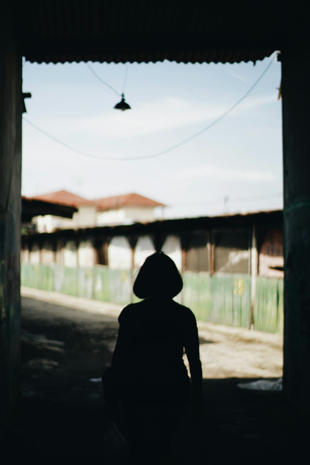 person in black hoodie standing on sidewalk during daytime