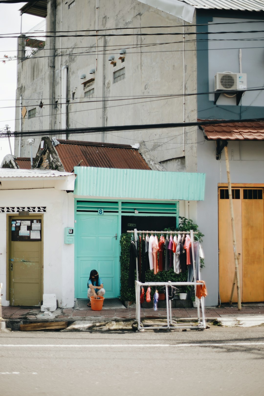 clothes hanged on clothes line near green wooden door