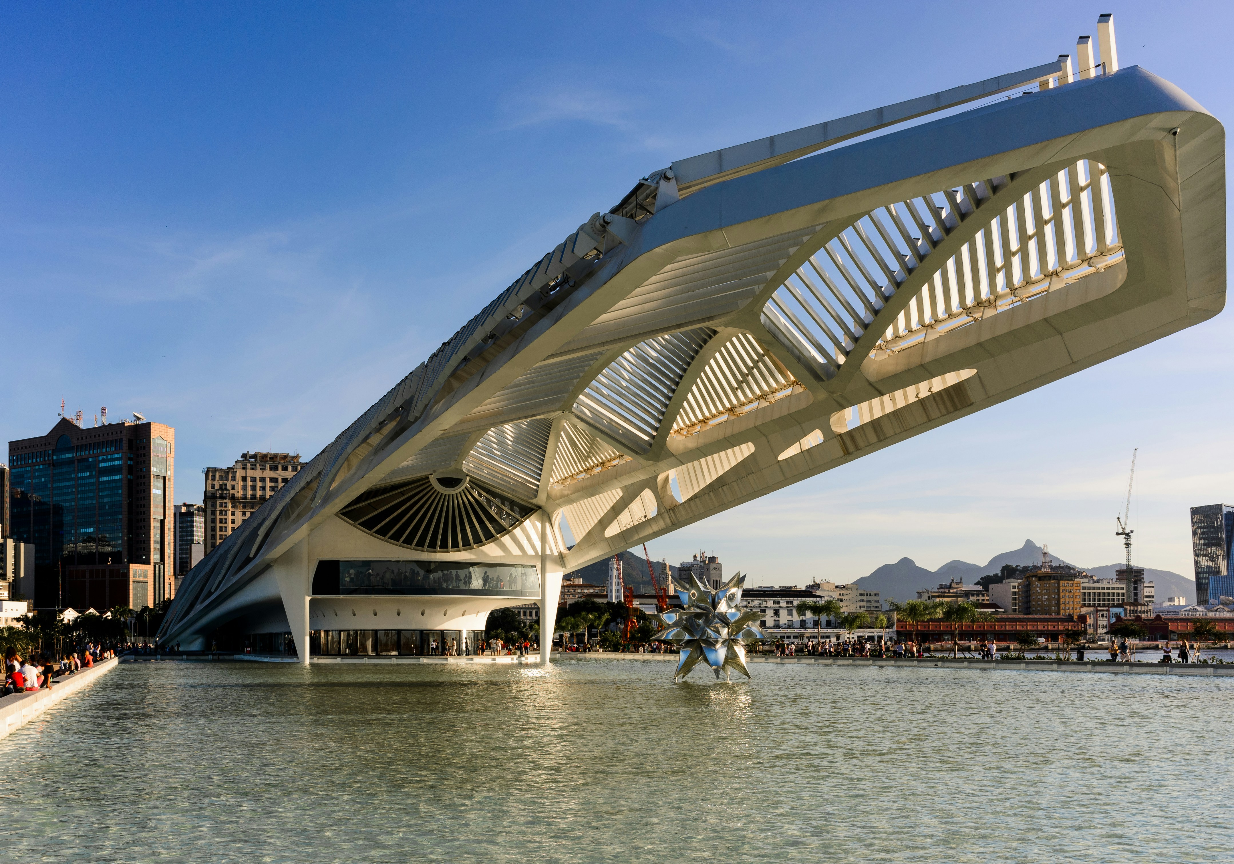 people walking on gray concrete bridge over body of water during daytime
