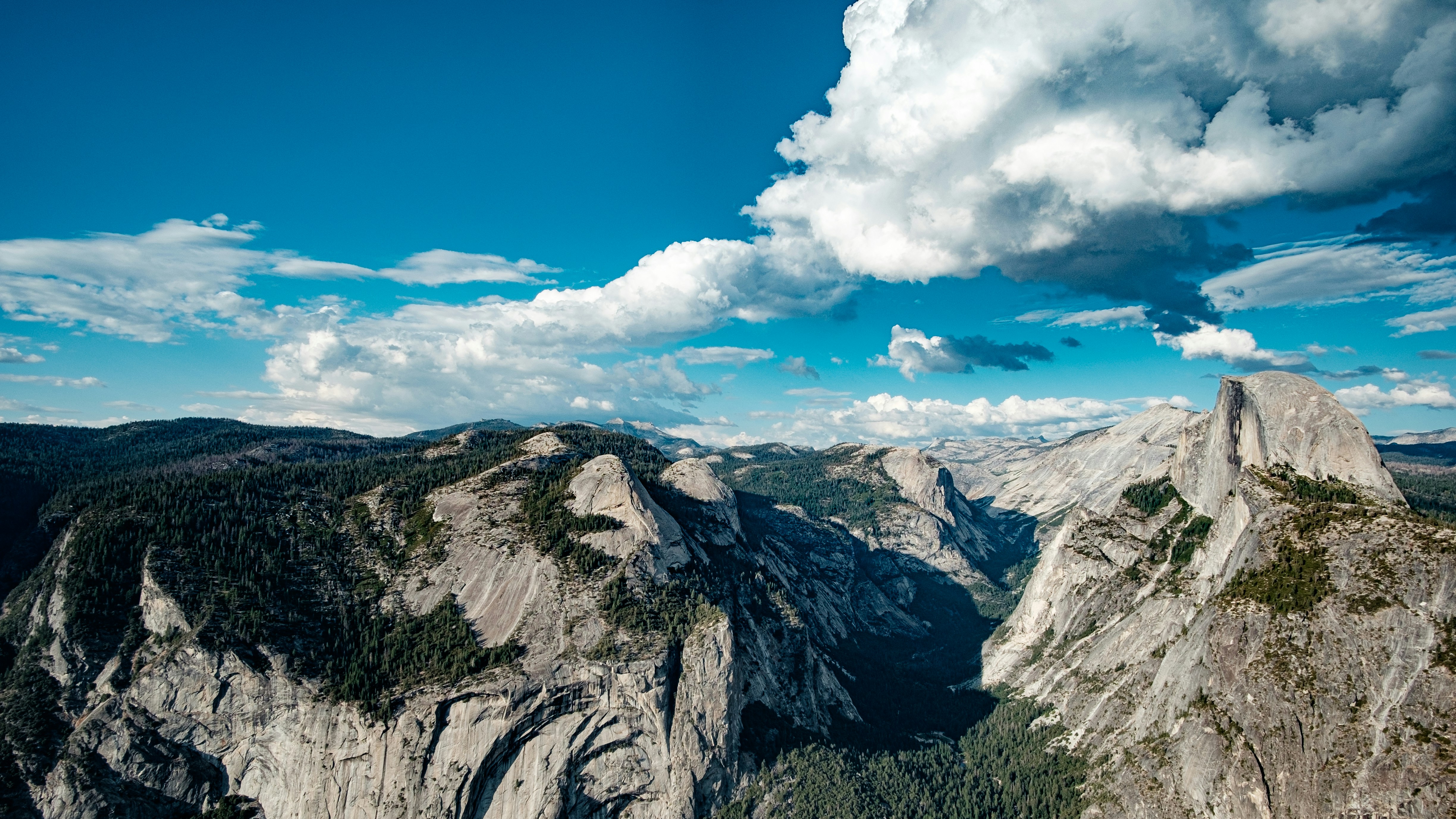 brown rocky mountain under blue sky and white clouds during daytime