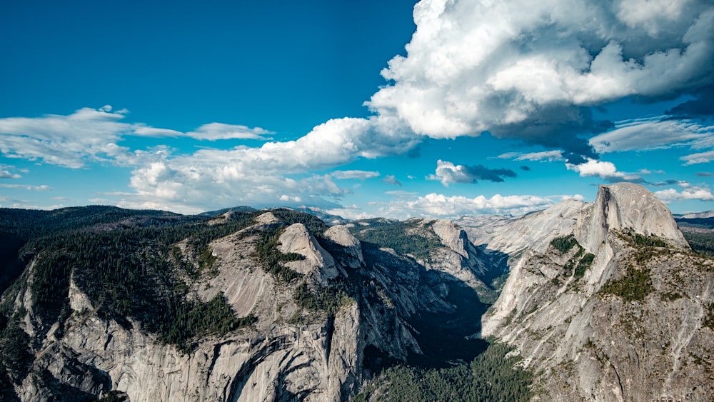 brown rocky mountain under blue sky and white clouds during daytime