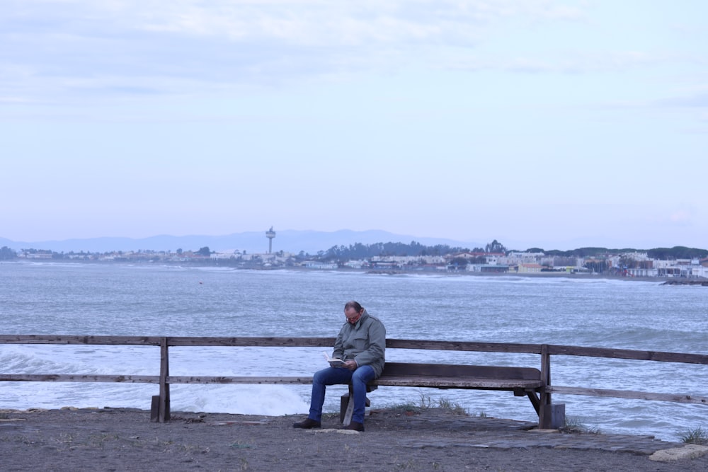 Mann und Frau sitzen tagsüber auf einer Bank in der Nähe von Gewässern