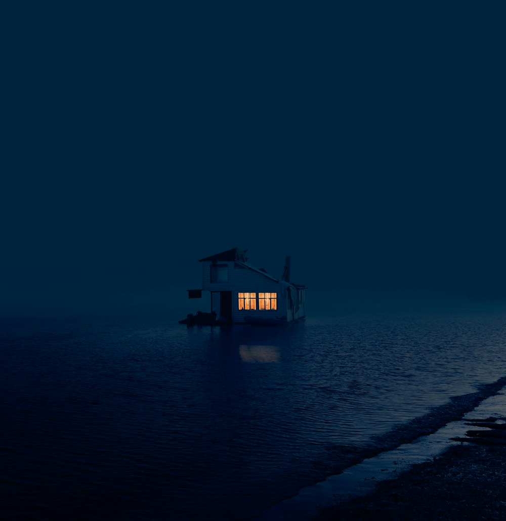 brown wooden house on sea shore during night time