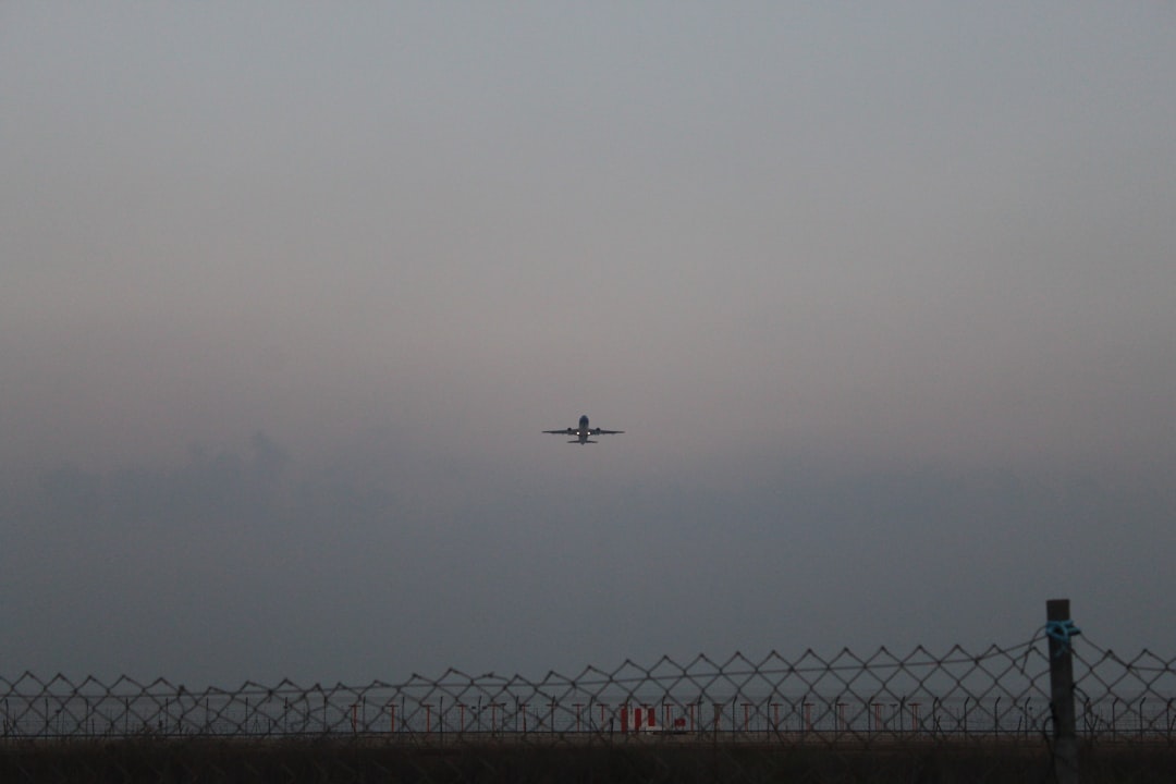 airplane flying over the city during foggy weather,