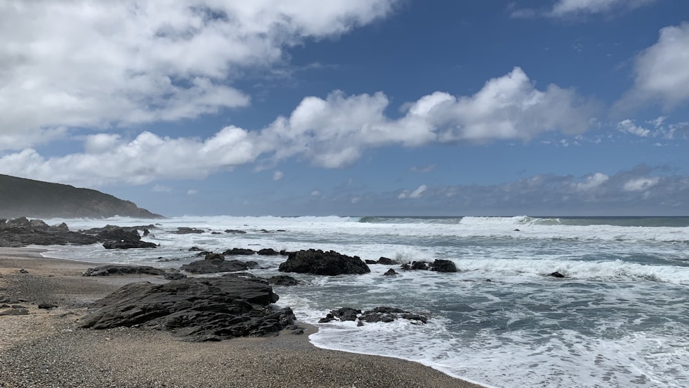 ocean waves crashing on shore during daytime