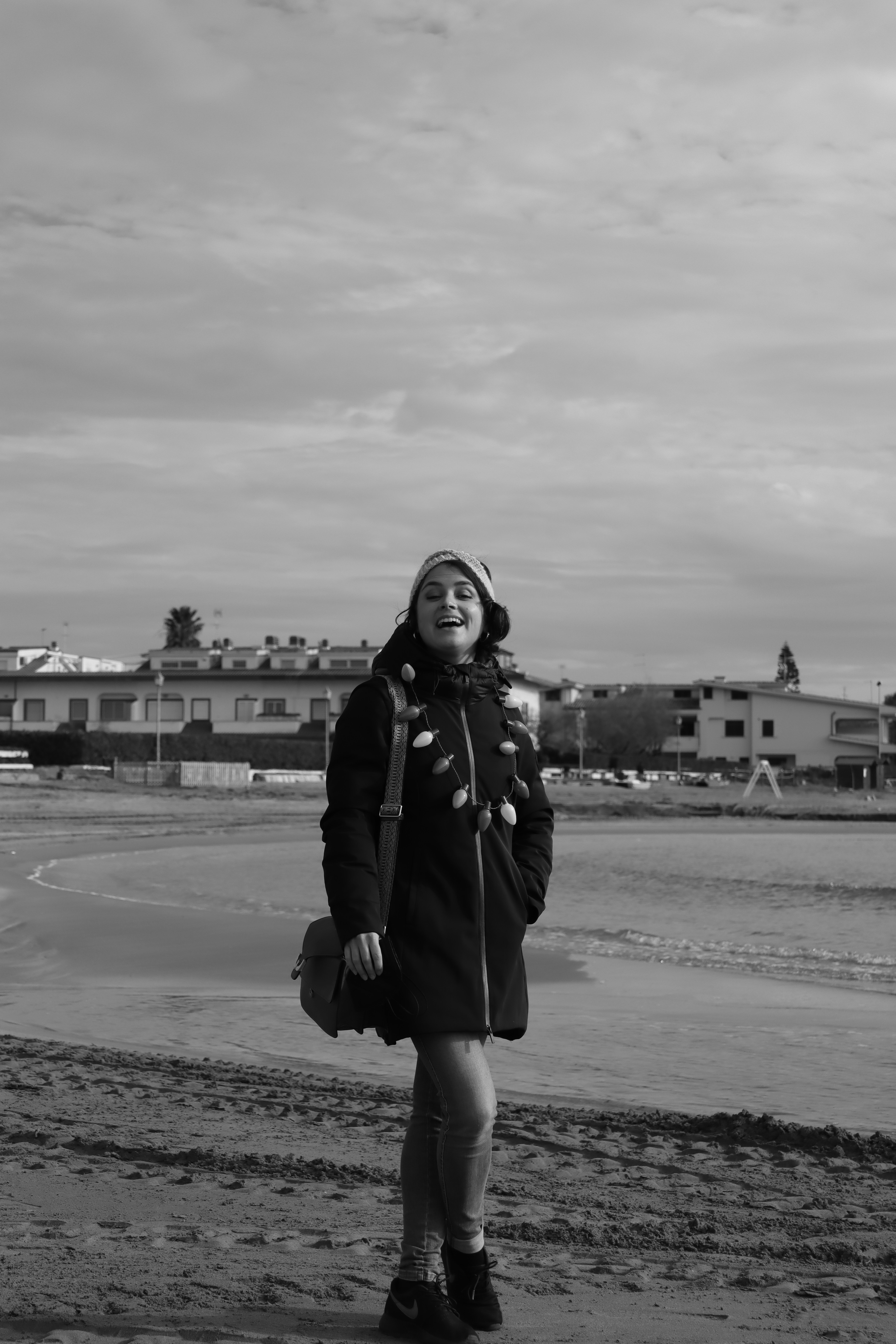 foto em tons de cinza da mulher no casaco preto e botas