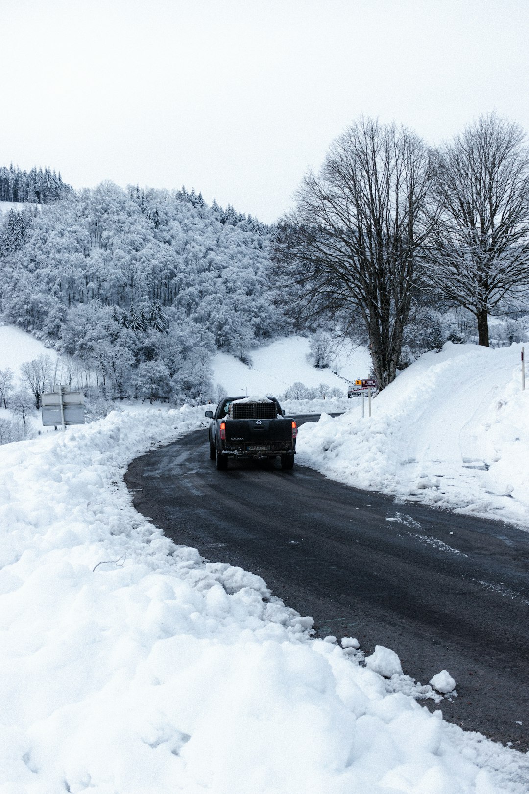 red car on snow covered road during daytime