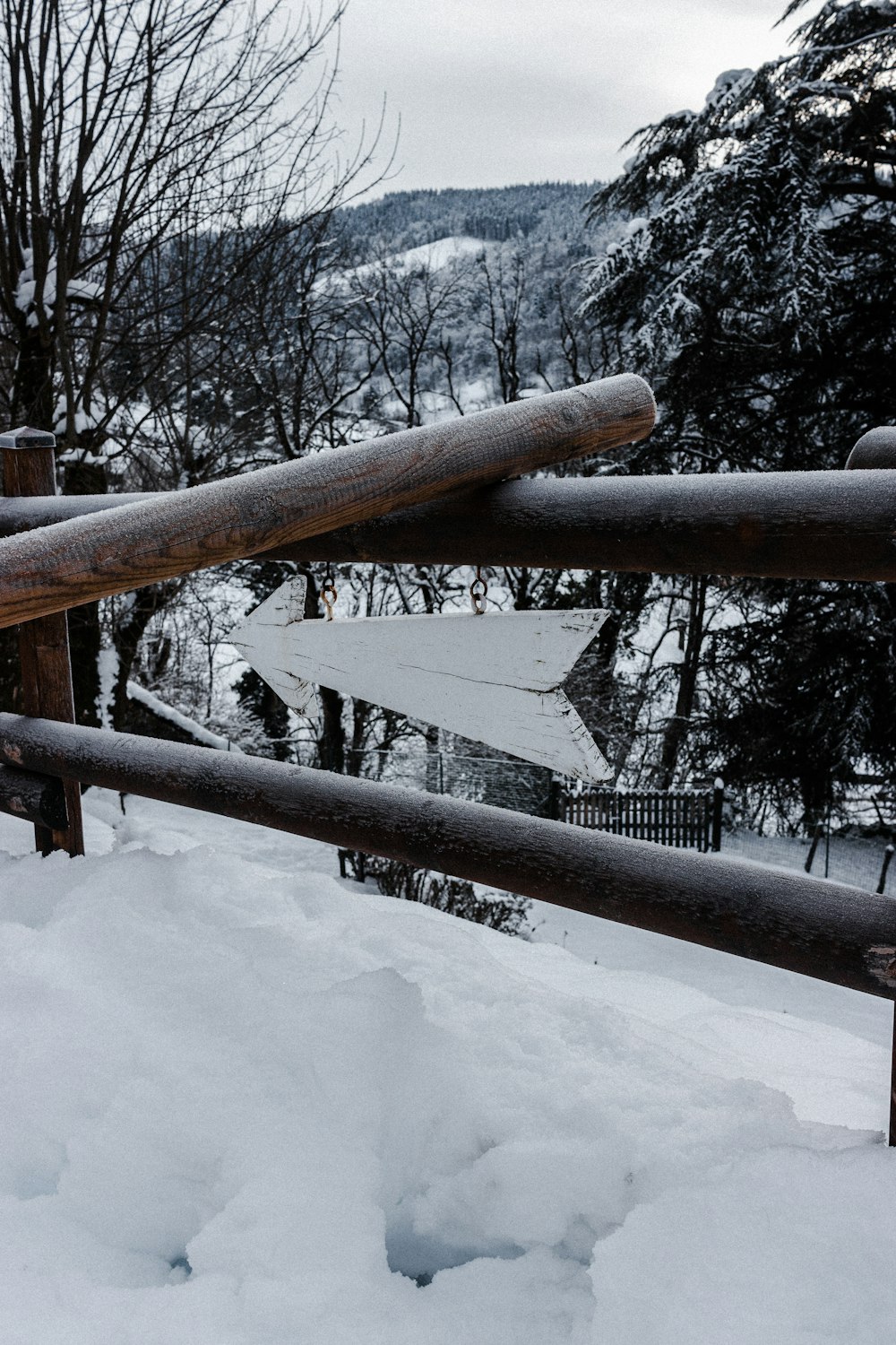 staccionata in legno marrone ricoperta di neve