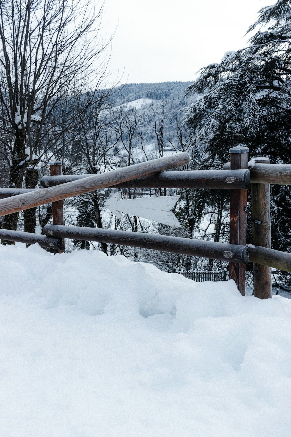 brown wooden fence covered with snow