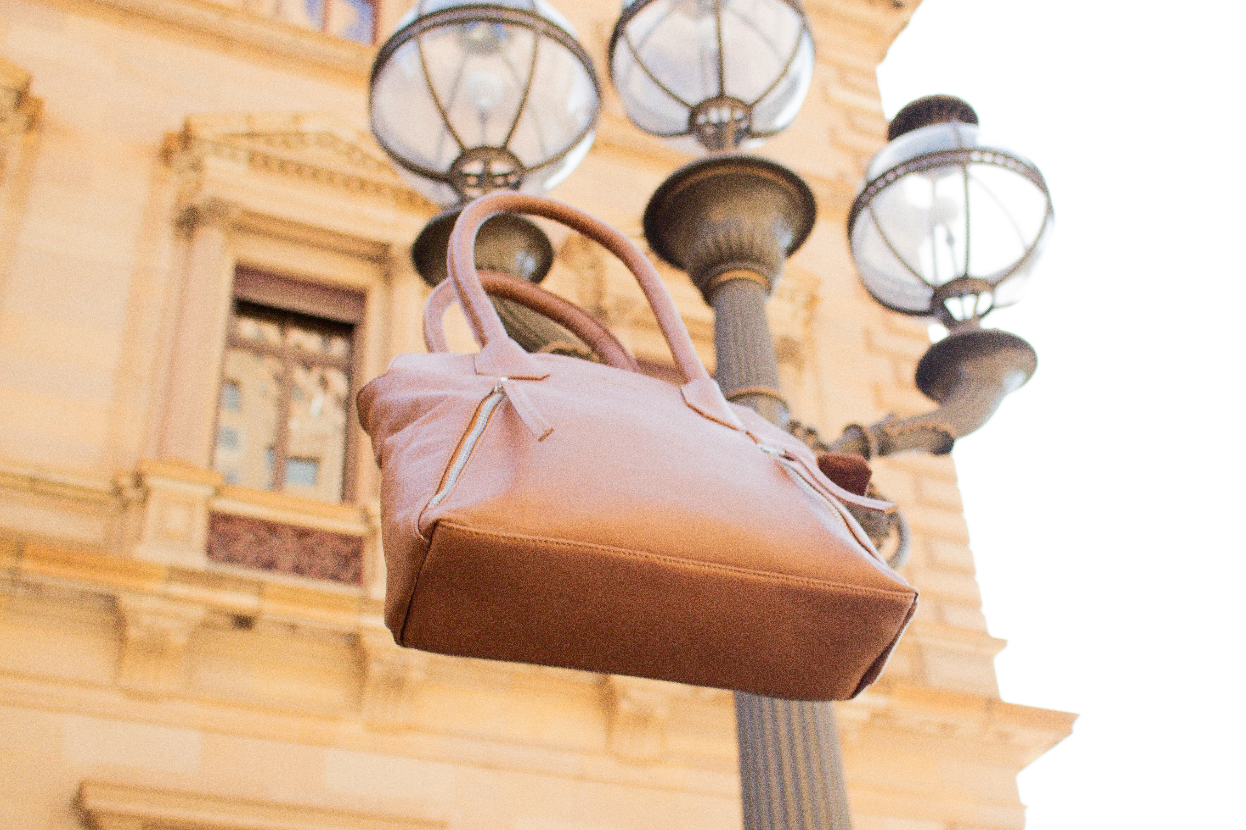 brown leather handbag on brown wooden stand