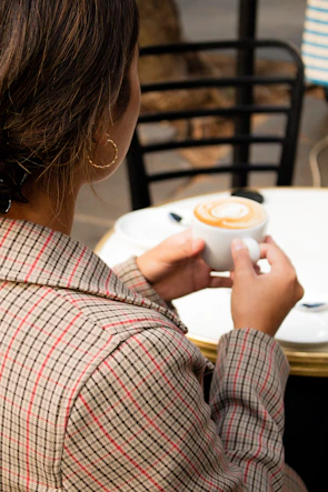 A customer wearing sanjoog's silver necklace at a cozy outdoor café.