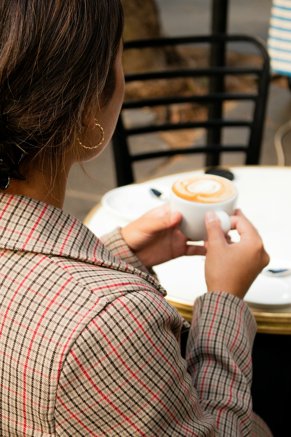 흰색 빨간색과 검은색 격자무늬 긴 소매 셔츠를 입은 여자 흰색 세라믹 머그잔을 들고 있다