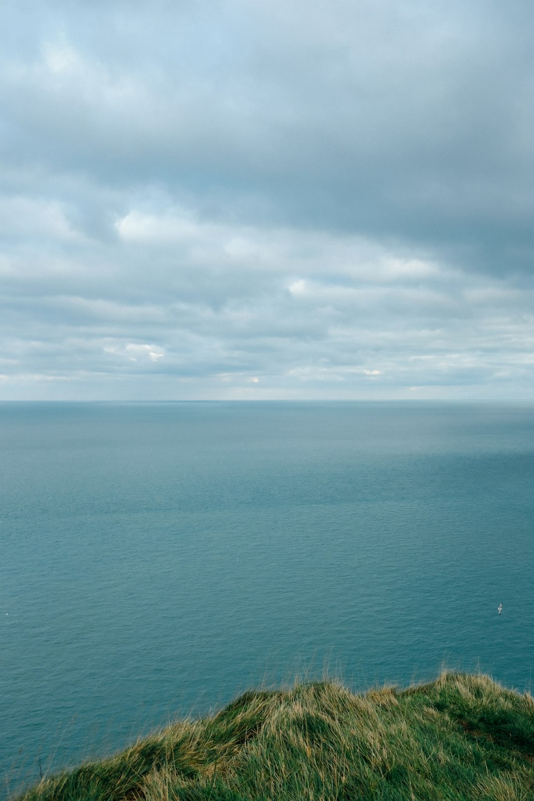 blue ocean under white clouds during daytime