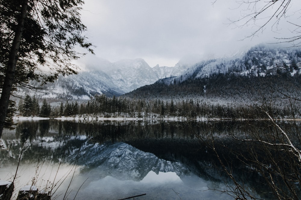 snow covered mountain near body of water during daytime