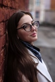 woman in black framed eyeglasses and white coat