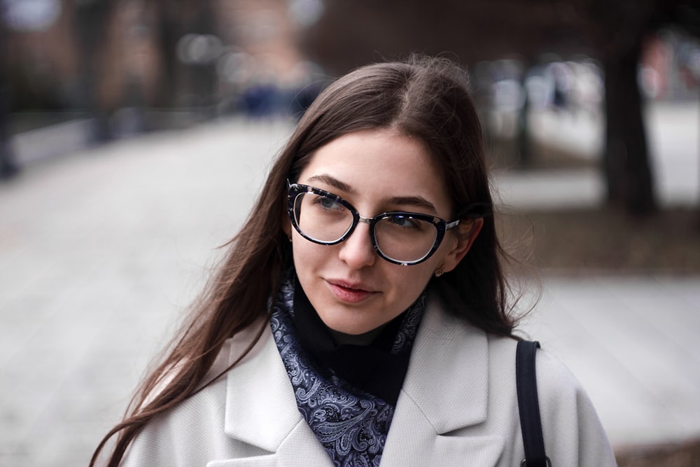 woman in black framed eyeglasses and white coat