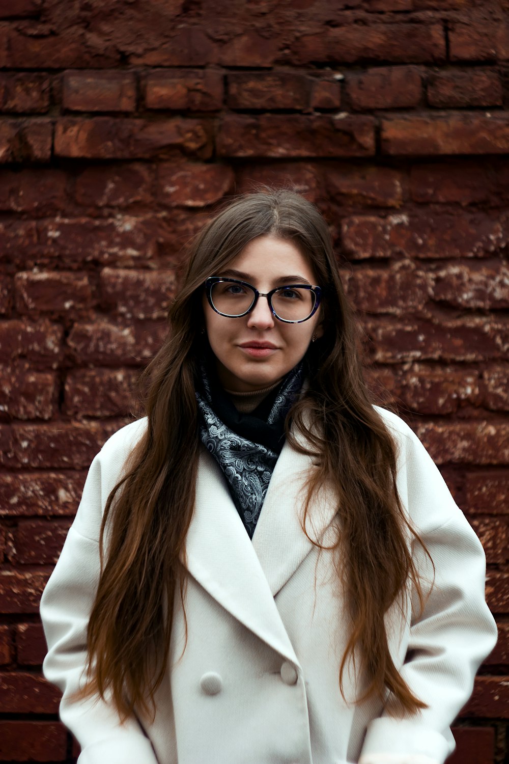 woman in white coat wearing black framed eyeglasses