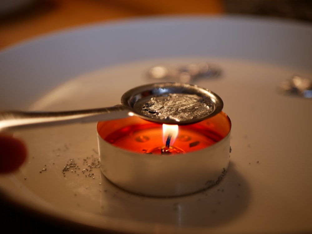 lighted candle on white ceramic plate