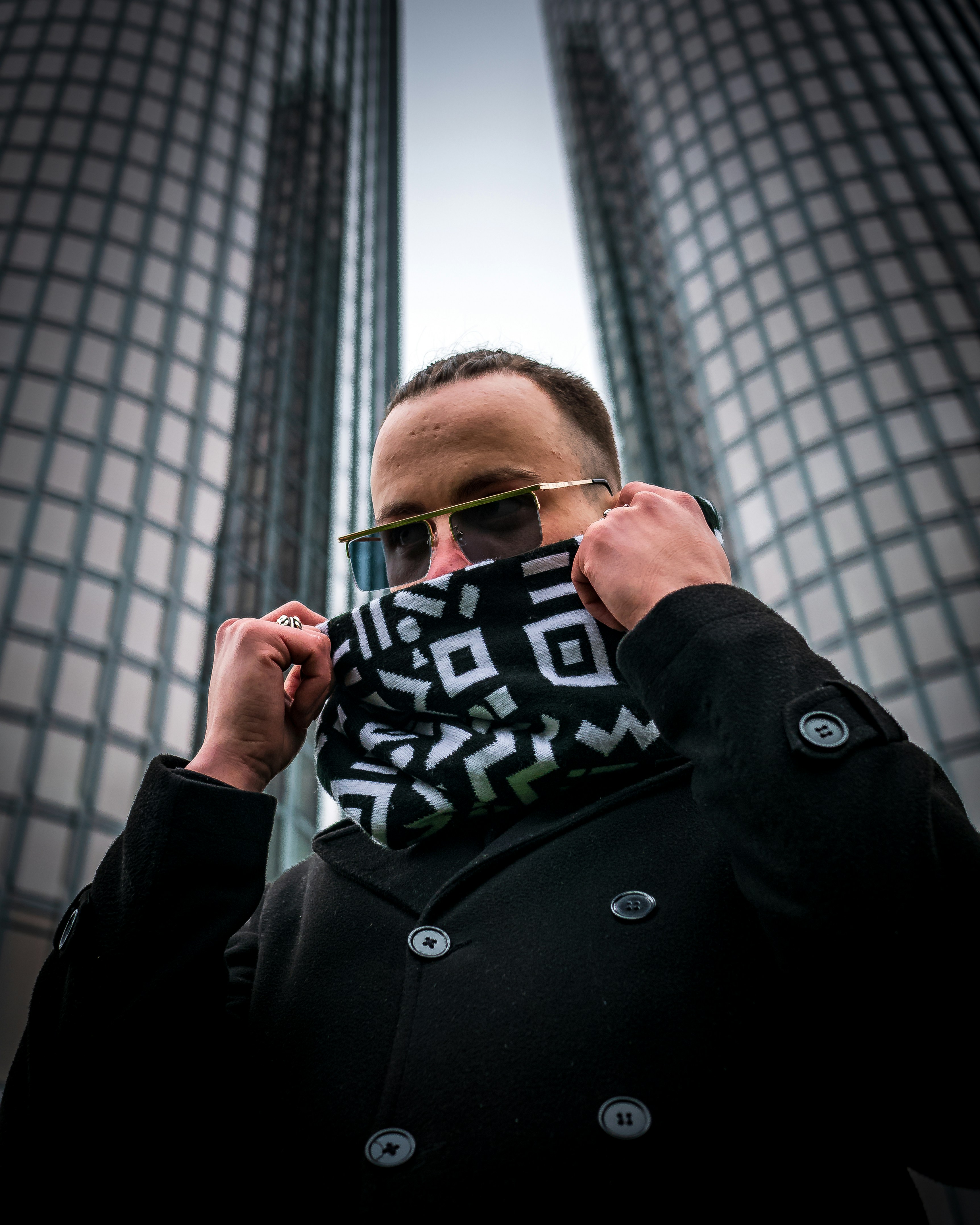 man in black coat holding black and white ceramic mug