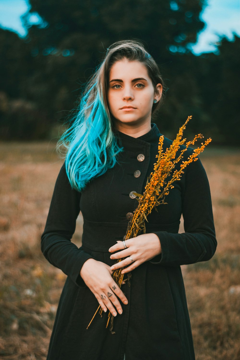 Femme en chemise noire à manches longues avec des cheveux bleus