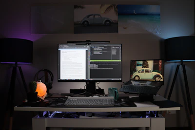 A sleek modern office setup with a laptop, printer, and African-inspired decor under soft blue lighting.