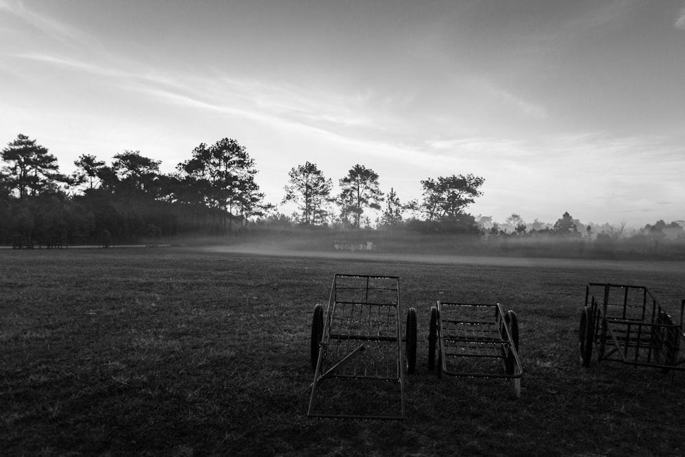 grayscale photo of a metal chair on a field