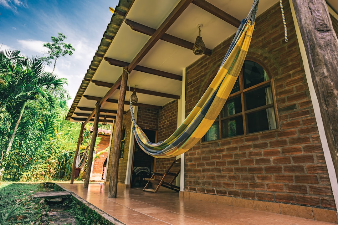 brown wooden hammock hanged on brown brick wall