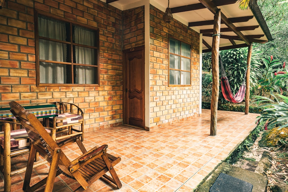 brown wooden armchair beside brown brick wall