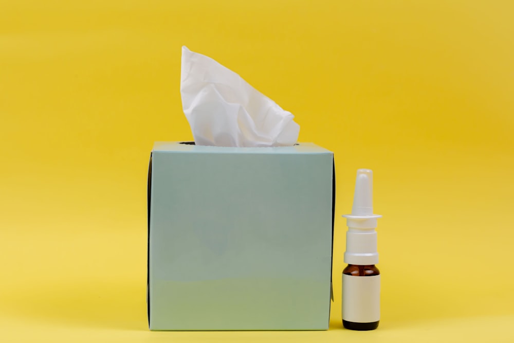 white and brown bottle beside white tissue box