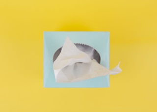 white paper boat on yellow surface