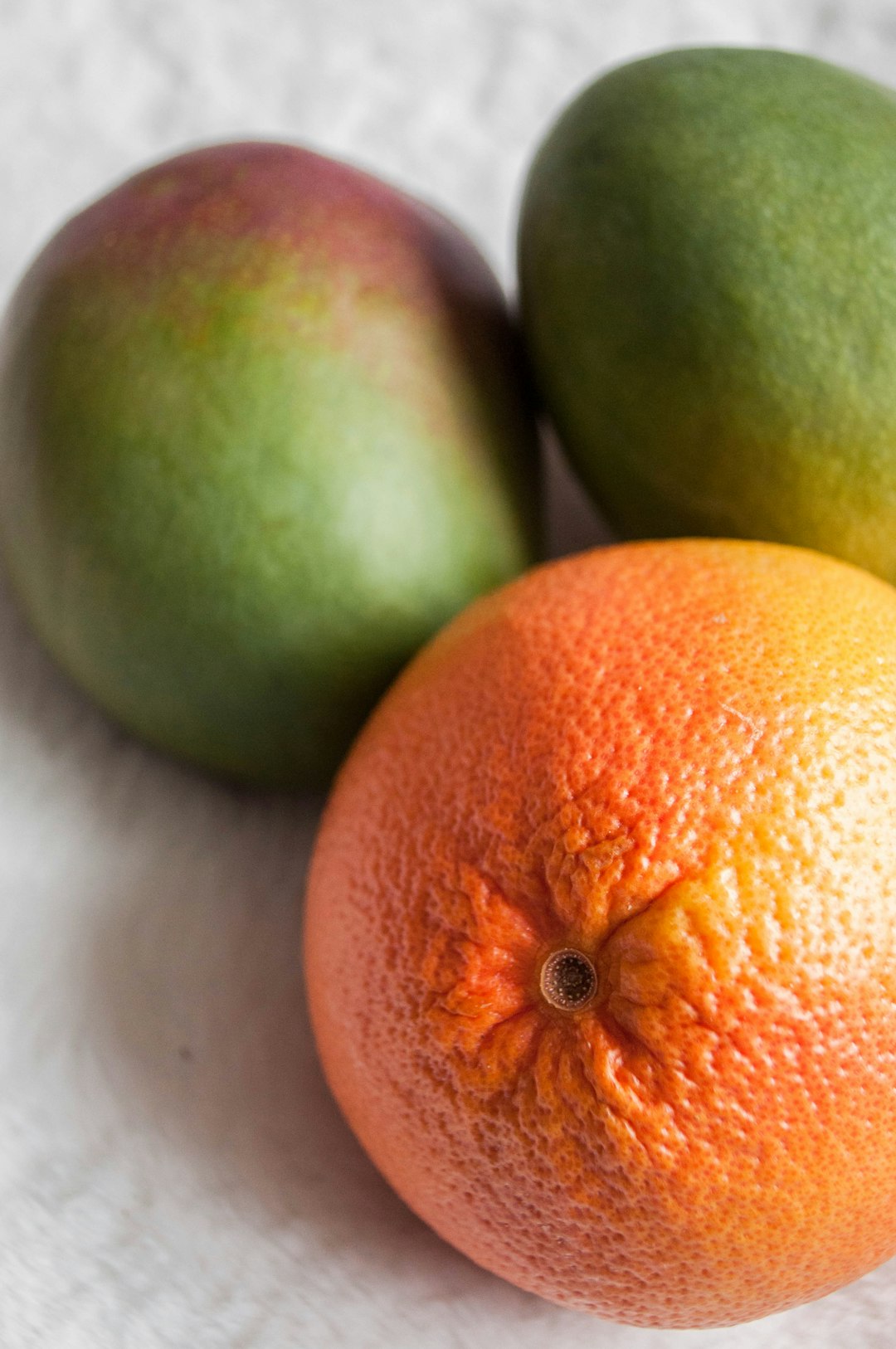 orange fruit beside green round fruits