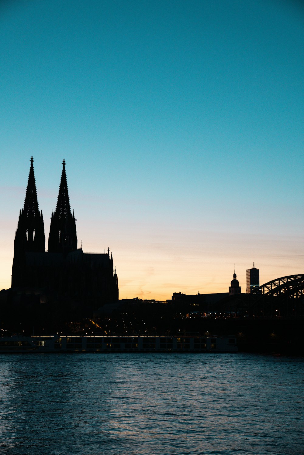 uma grande catedral que se eleva sobre uma cidade ao lado de um rio