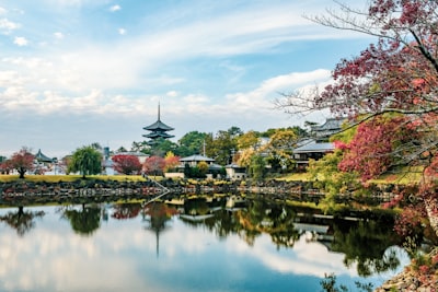 body of water near green trees under blue sky during daytime buddhist temple teams background