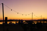 A serene outdoor event scene at sunset with tasteful lighting and decorations.