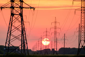 silhouette of electric post during sunset