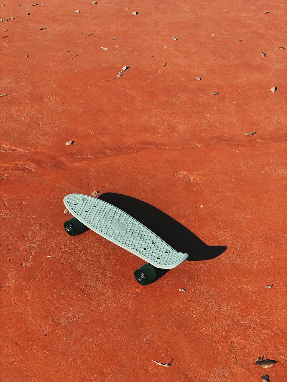 skateboard blanc et noir sur sable brun
