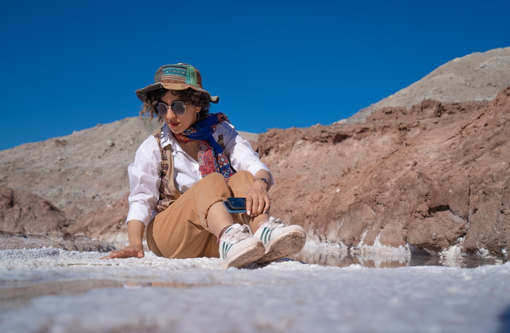 man in brown pants and brown leather boots sitting on brown rock during daytime