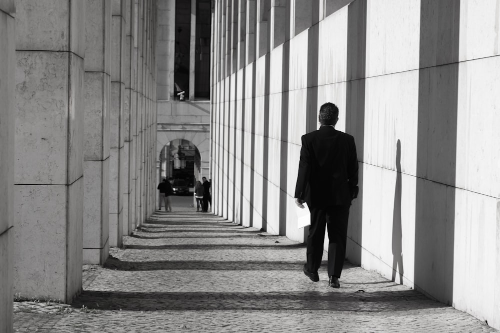 man in black suit walking on hallway