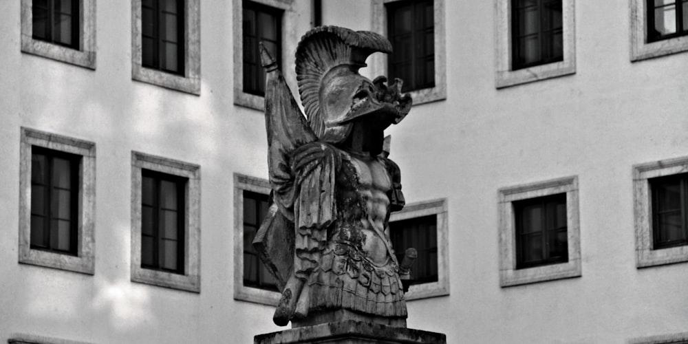 statue of man holding book