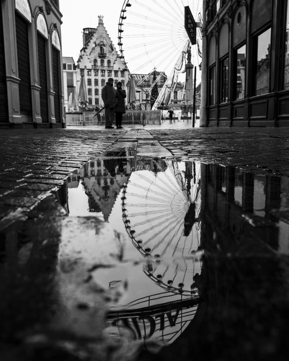 grayscale photo of person walking on sidewalk