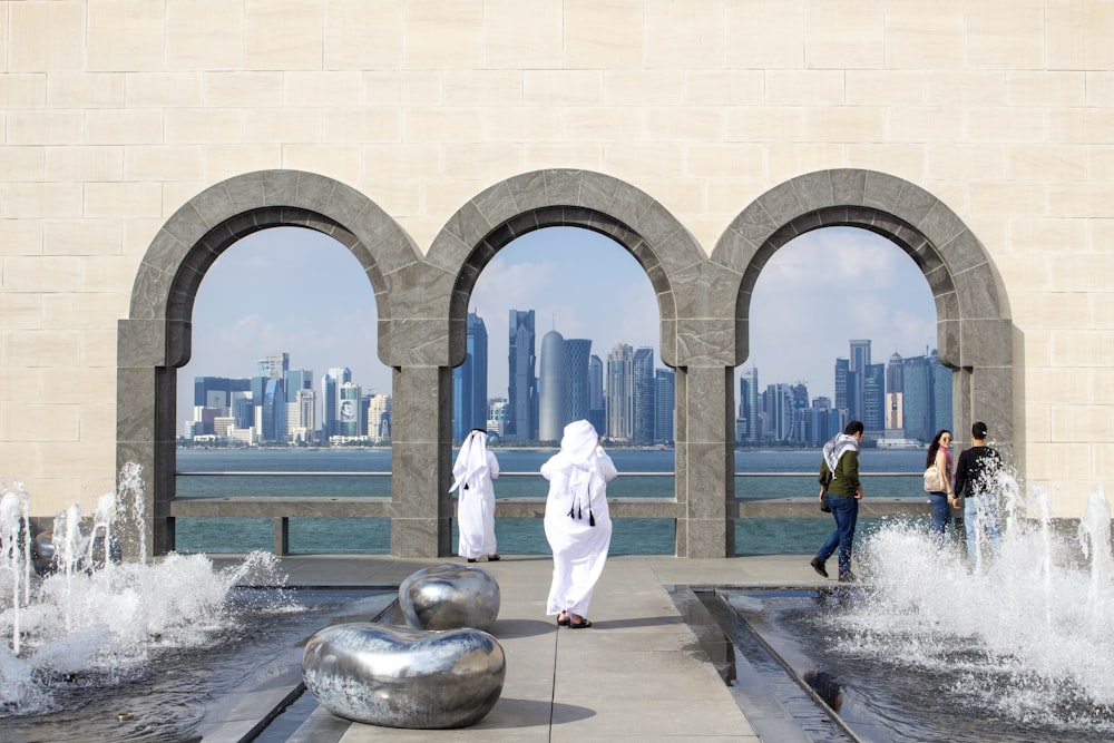 man in white robe standing near statue during daytime