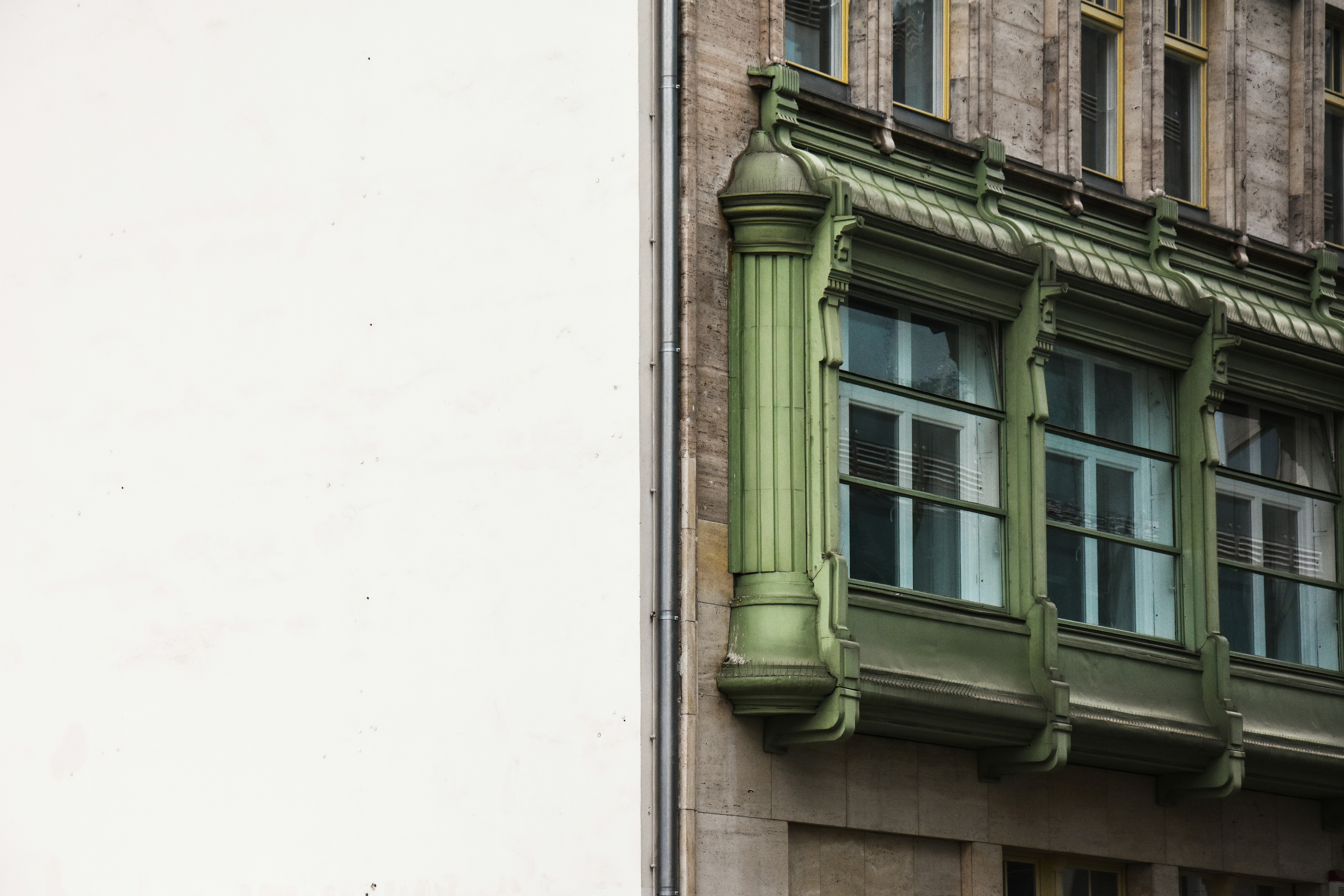 green wooden window frame on white concrete wall