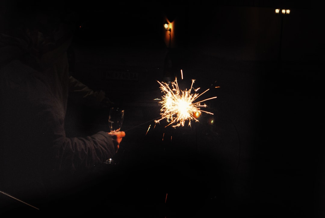 person holding sparkler during nighttime